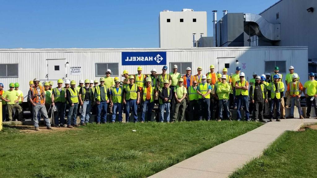 澳门足彩app team members standing near jobsite trailer.